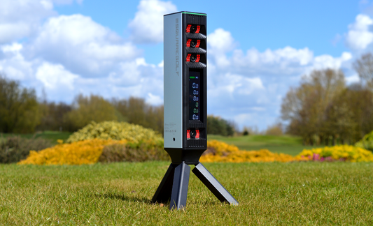Square Golf Omni launch monitor set up outdoors on a golf course, featuring four-camera infrared tracking for accurate golf simulator and driving range practice